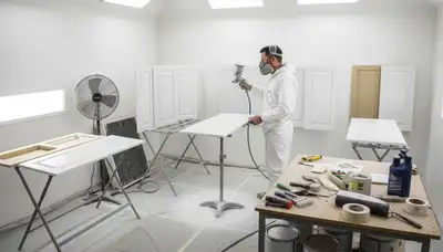Painter applying smooth cabinet finish in Mountain View, CA kitchen using professional spray technique
